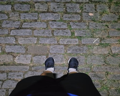 Person wearing comfortable sneakers standing on cobblestone in a German city