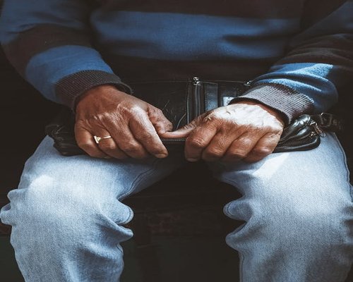Close up of a person adjusting their posture while sitting on a train