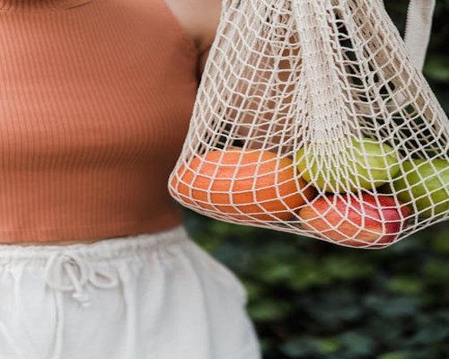 Woman carrying groceries in a reusable canvas bag